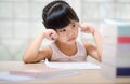 Decent school child. holding her head with a hand and reading a book