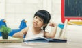 Decent school child. holding her head with a hand and reading a book Royalty Free Stock Photo