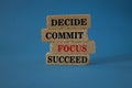 Decide commit focus succeed symbol. Concept word Decide Commit Focus Succeed on beautiful brick blocs. Beautiful blue background. Royalty Free Stock Photo