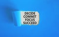 Decide commit focus succeed symbol. Concept word Decide Commit Focus Succeed on beautiful white paper. Beautiful blue paper