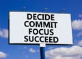 Decide commit focus succeed symbol. Concept word Decide Commit Focus Succeed on beautiful big billboard. Beautiful blue sky cloud Royalty Free Stock Photo