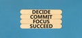 Decide commit focus succeed symbol. Concept word Decide Commit Focus Succeed on beautiful wooden stick. Beautiful blue table blue Royalty Free Stock Photo