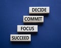 Decide Commit Focus Succeed symbol. Concept words Decide Commit Focus Succeed on wooden blocks. Beautiful deep blue background.