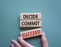 Decide Commit Succeed symbol. Concept words Decide Commit Succeed on wooden blocks. Businessman hand. Beautiful grey green