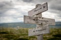 Decide commit and succeed text on wooden rustic signpost outdoors in nature/mountain scenery.