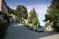 Decin, Czech republic - June 14, 2019: path, car, traffic sign, houses and trees at summer sunset