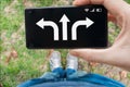 Decision concept. Man holds smartphone and is choosing direction