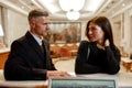 Decision making. Happy couple checking in hotel at reception desk. Man and woman looking at each other while waiting for Royalty Free Stock Photo