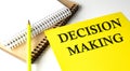 DECISION MAKING text written on a yellow paper with notebook Royalty Free Stock Photo