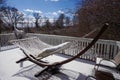 Frozen macrame hammock on a snow covered residential deck facing sun