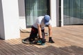 Deck builder sanding ipe wood boards with the professional orbital sander on exterior terrace Royalty Free Stock Photo