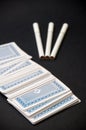 Deck of cards and three cigarettes spilled on the black background Royalty Free Stock Photo