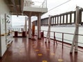 The deck of a cargo ship. Red floor and white walls.
