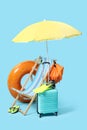 Deck chair, suitcase, backpack and beach accessories on light blue background Royalty Free Stock Photo