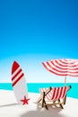 Deck chair under an umbrella with a surfboard on sandy beach by the sea and sky with copy space Royalty Free Stock Photo