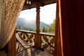 A deck chairs on balcony of the mountain spa resort apartment. Window view at wooden terrace with autumn forest Royalty Free Stock Photo