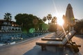 Deck chairs and parasols arranged in a row at poolside in tourist resort Royalty Free Stock Photo