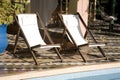 Deck chairs by swimming pool Royalty Free Stock Photo
