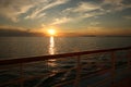 Cruise ship deck at sunset looking over the ocean towards land in the distance Royalty Free Stock Photo