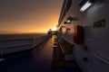 Deck of ferry sailing across the sea during last moments of a beautiful sunset with arriving land in the background. Concept of Royalty Free Stock Photo