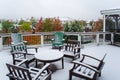 Deck furniture covered in early fall snowfall. porch ready for winter. chairs and a table covered in snow. snowstorm in Royalty Free Stock Photo