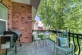 Deck of a house with barbecue grill, chairs and a view of the yard and neighborhood