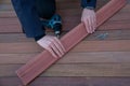 Deck installation carpenter hands holding ipe board, terrace decking construction wood work