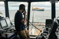 Deck navigation officer on the navigation bridge. He looks through binoculars Royalty Free Stock Photo