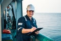 Deck Officer on deck of offshore vessel or ship , wearing PPE personal protective equipment. He fills checklist Royalty Free Stock Photo