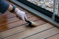 Deck staining, worker applying deck oil on decking boards with paint brush Royalty Free Stock Photo