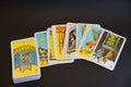 A deck of tarot cards laid out on a black background