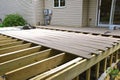 A partially constructed exterior deck with joists and posts in place Royalty Free Stock Photo