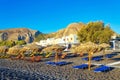 Deckchairs on peaceful morning beach Kamari Black beach Santorini Greece