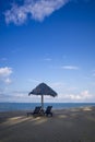 Deckchairs under the thatched roof on a beach, a tourist destination in Terengganu, Malaysia. Clean sandy beach with blue sea and