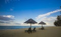 Deckchairs under the thatched roof on a beach, a tourist destination in Terengganu, Malaysia. Clean sandy beach with blue sea and