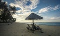 Deckchairs under the thatched roof on a beach, a tourist destination in Terengganu, Malaysia. Clean sandy beach with blue sea and