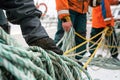 deckhands coiling ropes on a sailing boat deck Royalty Free Stock Photo