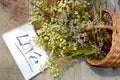 Declaration of love. A wicker basket with wildflowers and an inscription on the notebook Love. The word is written on a white