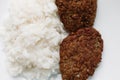 Declicious fried burger meal with white rice on rounded plate.