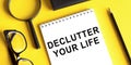 Declutter your life - motivational handwriting on a napkin with magnifier and glasses and pencil