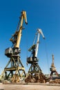 Decommissioned harbor cranes stand idle, symbols of industrial decline. Rust dominates steel structures. Outdated port Royalty Free Stock Photo