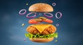 Deconstructed Fried Chicken Burger with Floating Ingredients Against a Blue Gradient Background Royalty Free Stock Photo