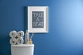 Decor elements, necessities and toilet bowl near blue wall. Bathroom Royalty Free Stock Photo