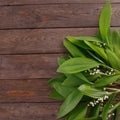 The decor of the flowers of lily of the valley on the background of vintage wooden boards. Vintage background with frame of Royalty Free Stock Photo