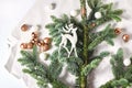 decor in the form of small balls and figures of a deer. green spruce branch on wrapping paper.
