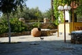 Three smooth-haired cats walk near a large clay pot or amphora in Lardos, Rhodes Island, South Aegean region, Greece Royalty Free Stock Photo