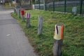 Boundary roadside poles decorated with knitted products against the background of grass with hoarfrost in December. Berlin, German