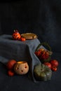 halloween decor, pumpkin pie, lantern, basket with berries lie on gray tablecloth on a black background