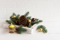 Decor to celebrate the new year and Christmas. wooden box with colorful balls and cedar cone