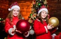 Decorate christmas tree together. Girls sisters santa claus costumes. Kids lovely friends meet Christmas holiday. Family